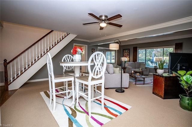 dining space with ornamental molding, carpet floors, and ceiling fan