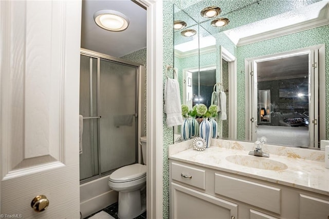 full bathroom with vanity, crown molding, bath / shower combo with glass door, and toilet