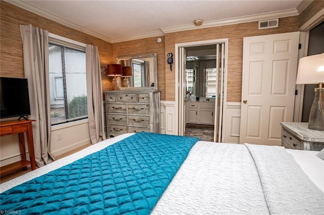 bedroom with connected bathroom and crown molding