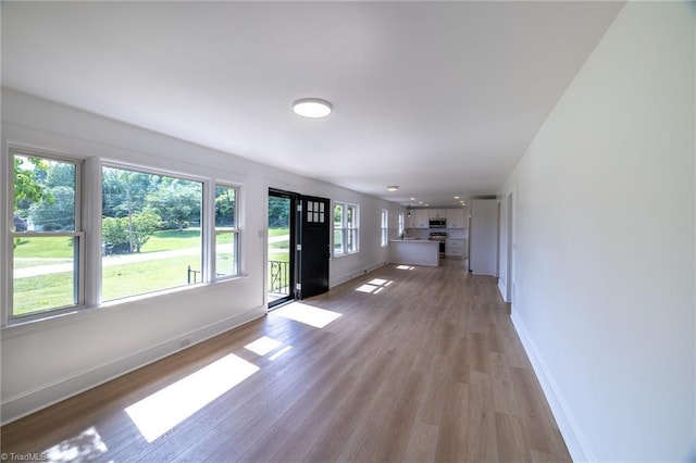 unfurnished living room with light wood-style floors and baseboards