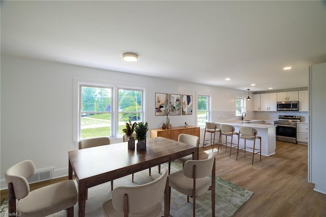 dining room featuring light wood-style flooring and recessed lighting
