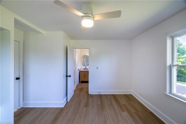 unfurnished room with wood finished floors, ceiling fan, and baseboards