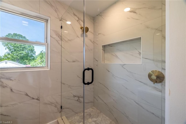 full bathroom featuring a marble finish shower and healthy amount of natural light