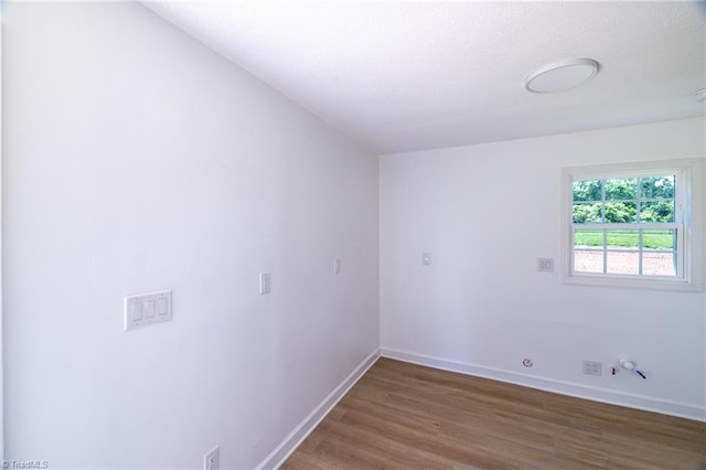 unfurnished room featuring wood finished floors, baseboards, and a textured ceiling