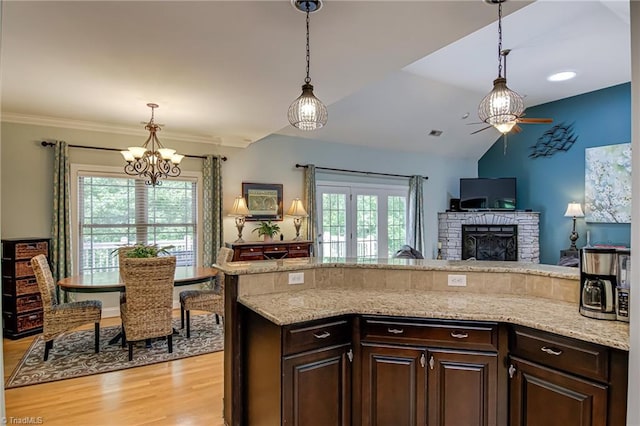 kitchen with plenty of natural light, a chandelier, open floor plan, light wood-style flooring, and lofted ceiling