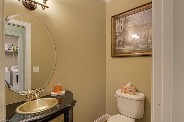 bathroom with toilet, vanity, and baseboards
