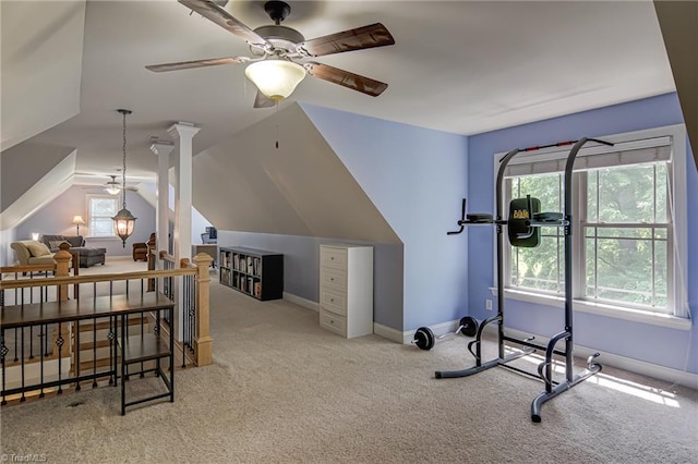 exercise area featuring carpet floors, a ceiling fan, vaulted ceiling, and baseboards