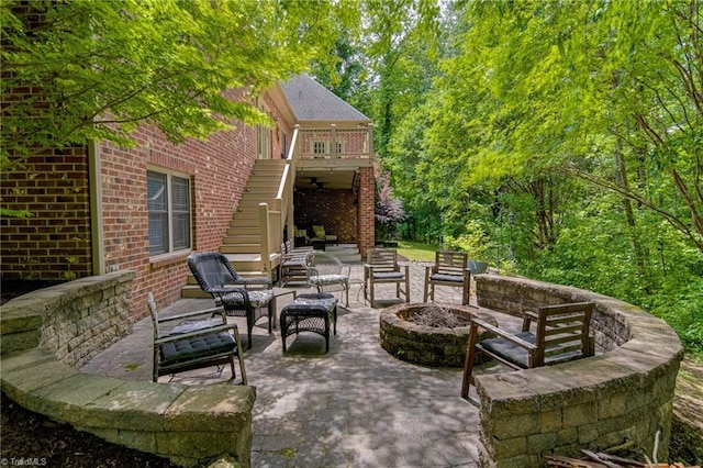 view of patio featuring stairway and an outdoor living space with a fire pit
