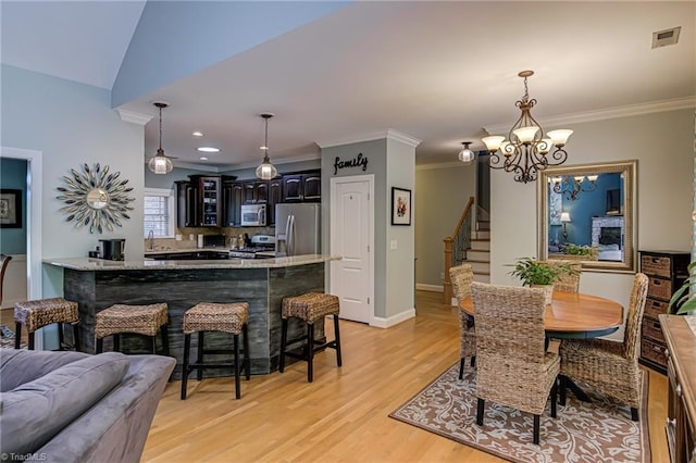dining space with light wood-type flooring, stairway, crown molding, a chandelier, and baseboards
