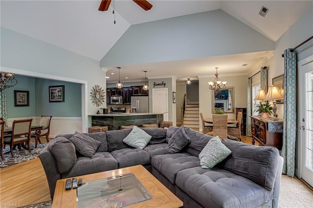 living room featuring a chandelier, a ceiling fan, stairs, plenty of natural light, and high vaulted ceiling