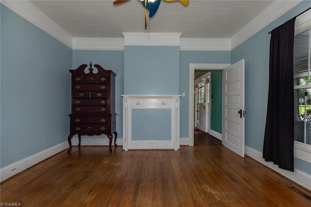 living room with wood finished floors, baseboards, healthy amount of natural light, and crown molding