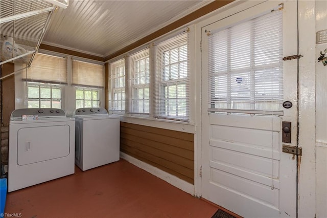 clothes washing area featuring washing machine and clothes dryer and crown molding