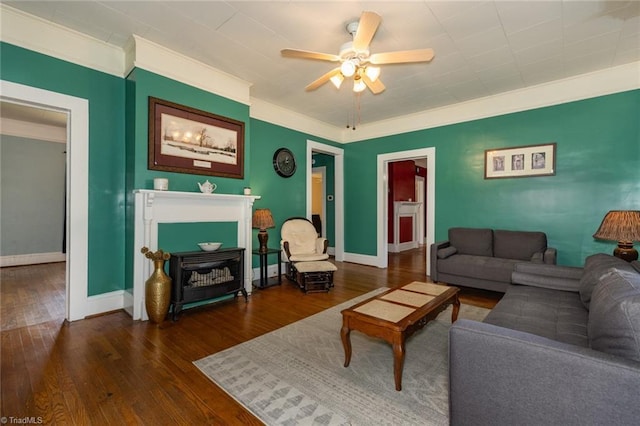 living room featuring ornamental molding, hardwood / wood-style flooring, ceiling fan, and baseboards