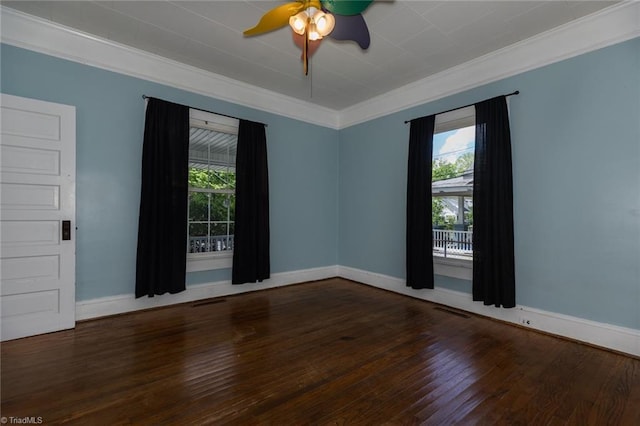 spare room featuring crown molding, healthy amount of natural light, hardwood / wood-style floors, and baseboards