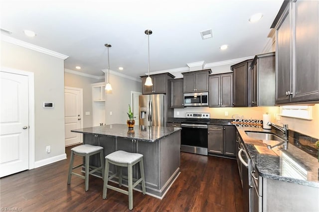 kitchen with dark stone counters, stainless steel appliances, dark wood finished floors, and a sink