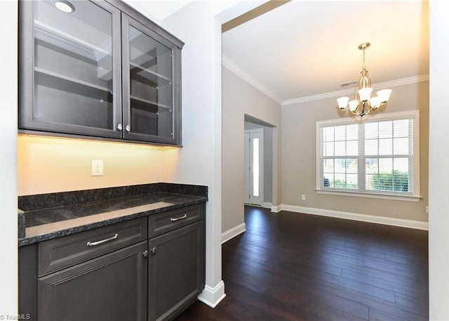 kitchen with ornamental molding, glass insert cabinets, baseboards, dark wood-style floors, and a chandelier