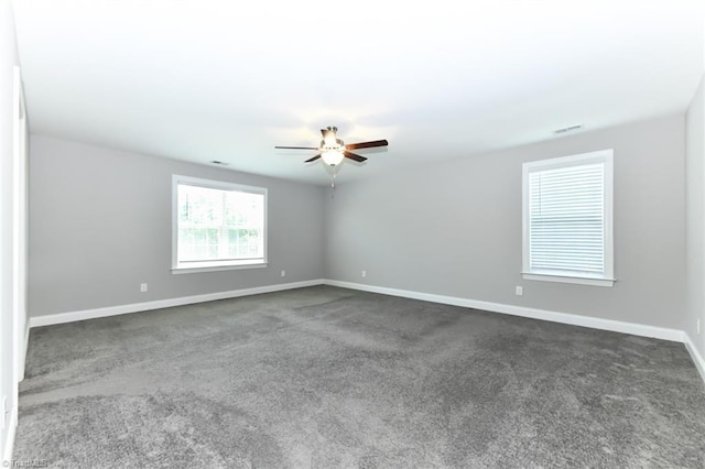 empty room featuring a ceiling fan, baseboards, visible vents, and dark colored carpet