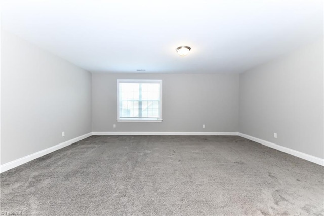 spare room featuring carpet floors and baseboards