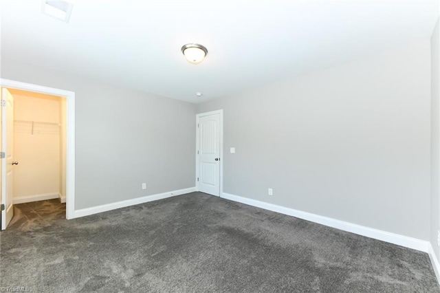 unfurnished bedroom with baseboards and dark carpet