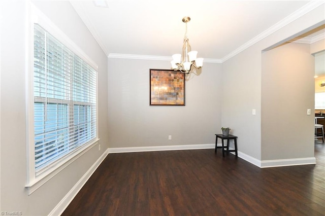 unfurnished room featuring crown molding, baseboards, a chandelier, and wood finished floors