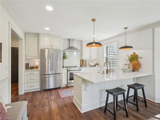 511 Circle Dr, Burlington, NC 27215 - kitchen with a kitchen bar, wall chimney range hood, appliances with stainless steel finishes, a sink, and light countertops