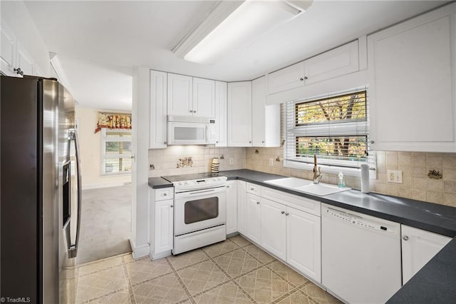 kitchen with tasteful backsplash, sink, white cabinets, and white appliances