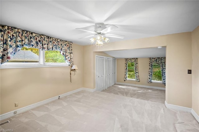 unfurnished room featuring light colored carpet and ceiling fan