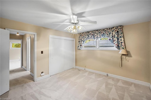 carpeted empty room with ceiling fan and plenty of natural light