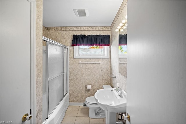 full bathroom featuring shower / bath combination with glass door, sink, toilet, and tile patterned flooring