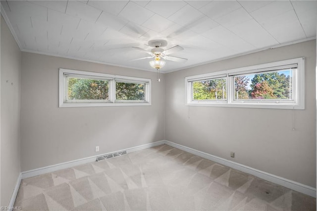 empty room with ornamental molding, light colored carpet, and ceiling fan