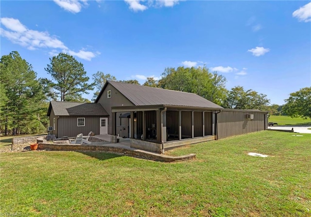 back of property featuring a yard, a patio, and a sunroom