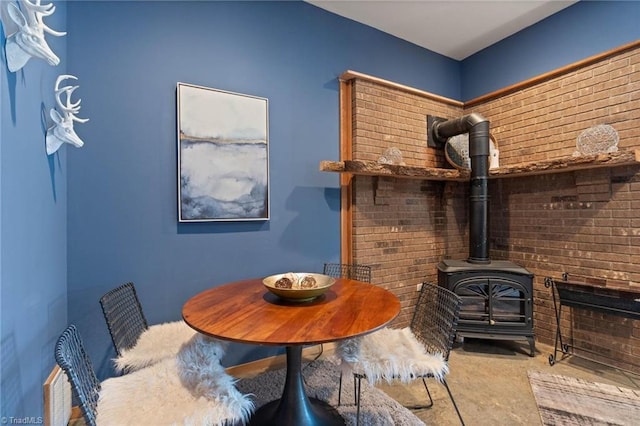 dining space featuring carpet flooring and a wood stove