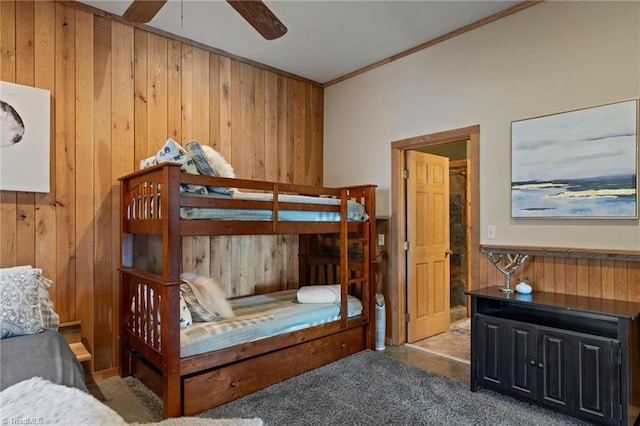 bedroom with carpet, wood walls, and ornamental molding