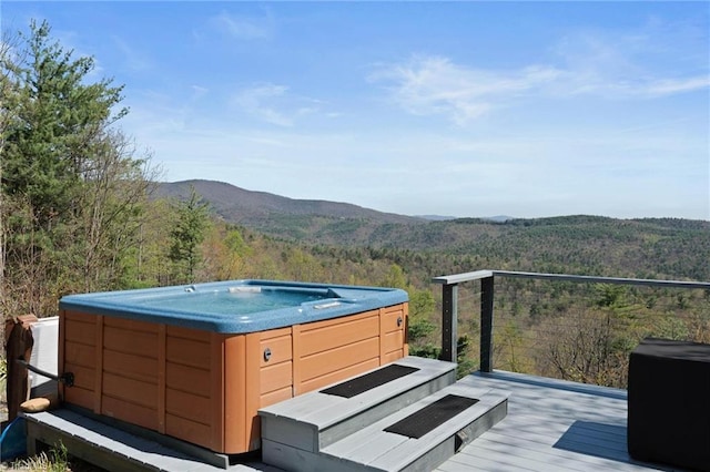 exterior space featuring a view of trees, a hot tub, and a mountain view