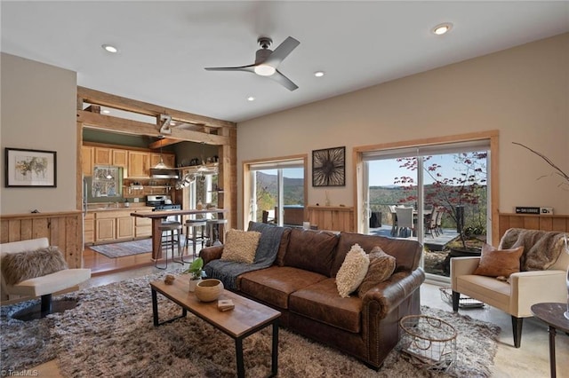 living room with a ceiling fan, a wainscoted wall, and recessed lighting