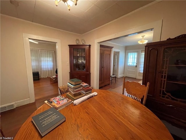 dining area with crown molding and hardwood / wood-style flooring