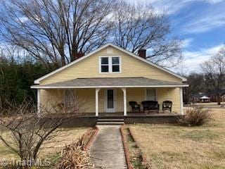 view of front of house featuring covered porch and a front lawn