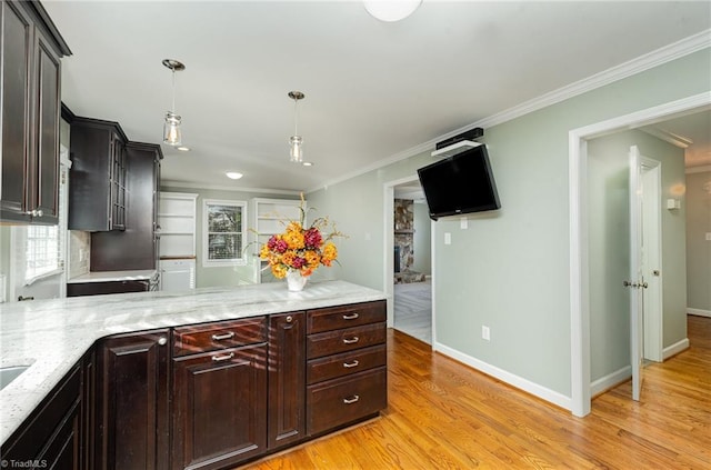 kitchen featuring pendant lighting, light wood-style flooring, ornamental molding, dark brown cabinetry, and baseboards