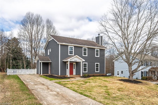 view of front of property featuring a chimney, a front yard, and fence