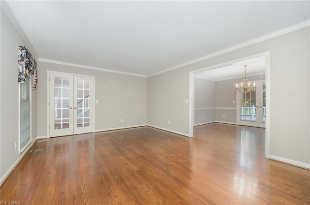 1808 Dunleith Way, Greensboro, NC 27455 - spare room with french doors, a chandelier, wood finished floors, and ornamental molding