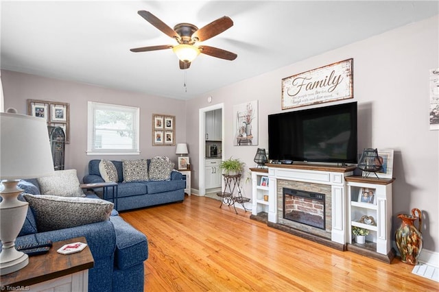 422 Hyde St, Burlington, NC 27217 - living room featuring a ceiling fan, wood finished floors, a fireplace, and baseboards