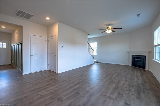 unfurnished living room featuring ceiling fan, dark wood-style floors, recessed lighting, baseboards, and a glass covered fireplace