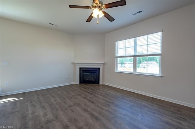 unfurnished living room featuring dark wood-type flooring, baseboards, a fireplace, and ceiling fan