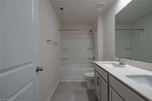 bathroom with toilet, double vanity, tile patterned floors, baseboards, and shower / bath combination