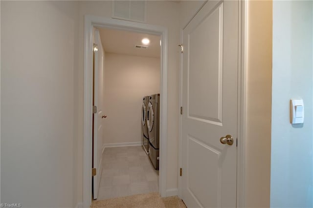 laundry area with washer and dryer, light floors, and baseboards
