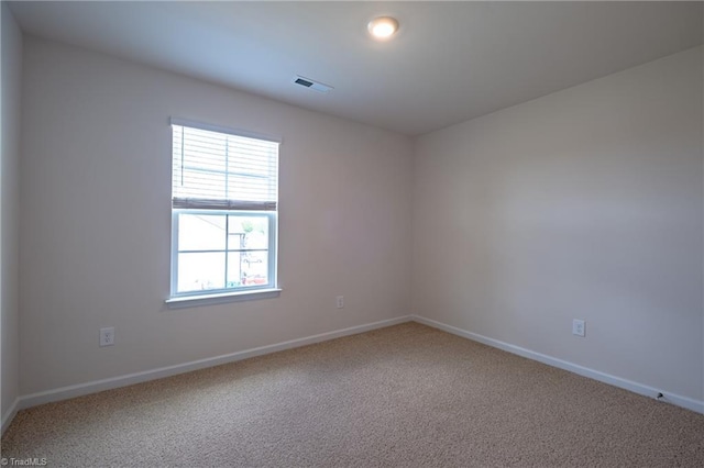 spare room featuring carpet floors and baseboards