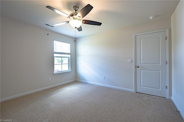 carpeted empty room with ceiling fan, baseboards, and a smoke detector