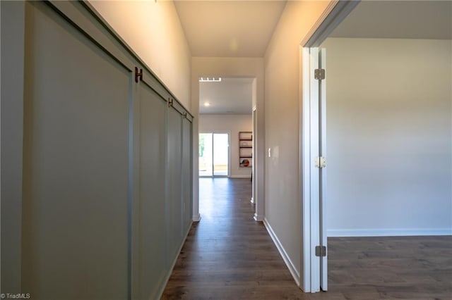 corridor with dark wood-style floors and baseboards