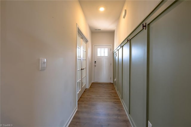 hall featuring wood finished floors and baseboards