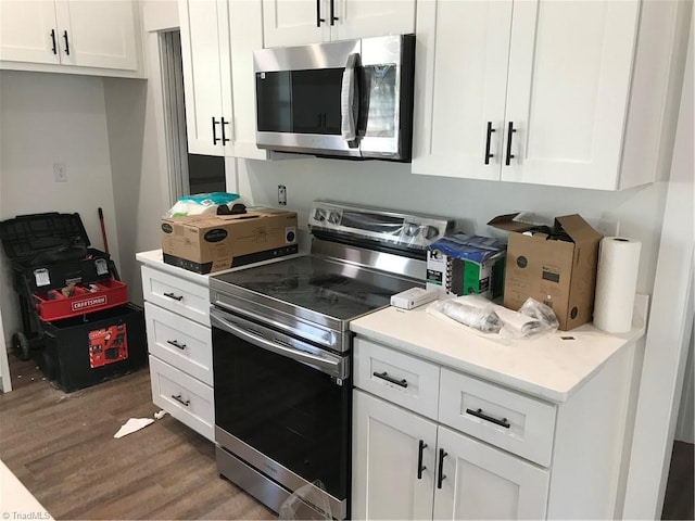 kitchen with white cabinetry, stainless steel appliances, and dark hardwood / wood-style floors